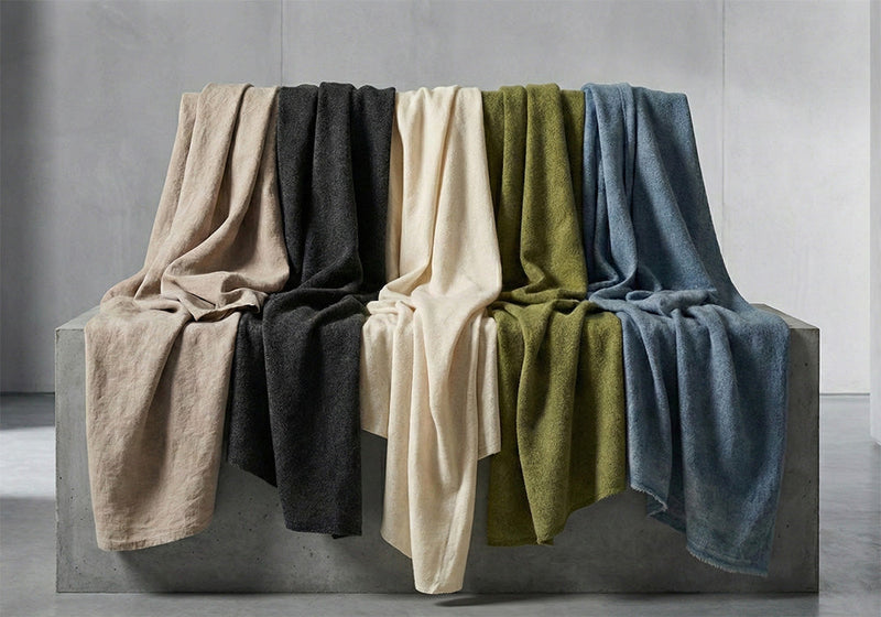 Verschiedene textile Stoffe drapiert auf einem grauen Betonblock